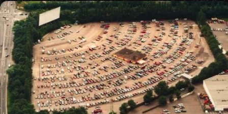 Luftaufnahme des Autokinos in Köln mit zahlreichen abgestellten Fahrzeugen, hier begann 1992 der Autohandel von Herrn Eyice